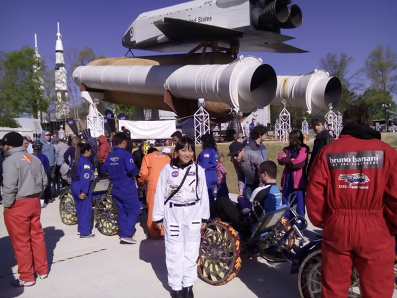 スペースシャトルの実物大模型の前で記念写真を撮る日本人留学生